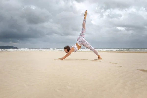 Young beautiful woman practice yoga on sea sand — 스톡 사진