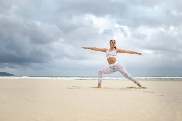 Młoda piękna kobieta ćwiczy jogę na piasku morskim — Zdjęcie stockowe