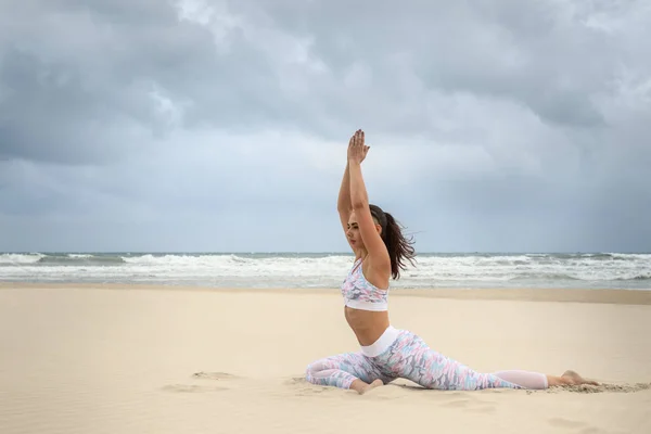 Młoda piękna kobieta ćwiczy jogę na piasku morskim — Zdjęcie stockowe