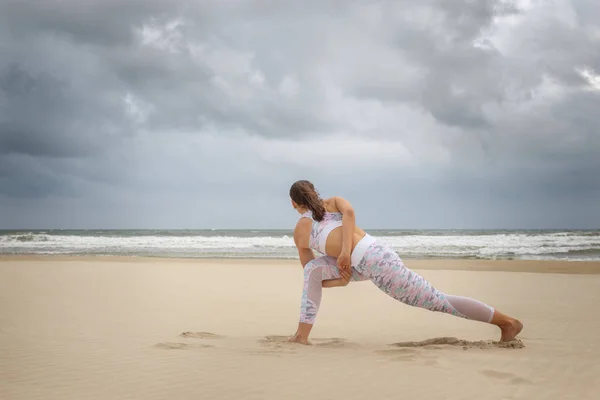 Young beautiful woman practice yoga on sea sand — Stock Photo, Image