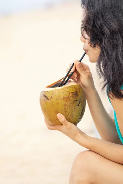 Young asian woman with coconut on the beach — 스톡 사진