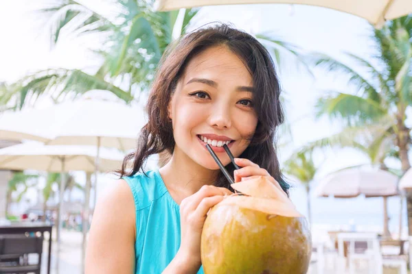 Joven mujer asiática con coco en la playa —  Fotos de Stock