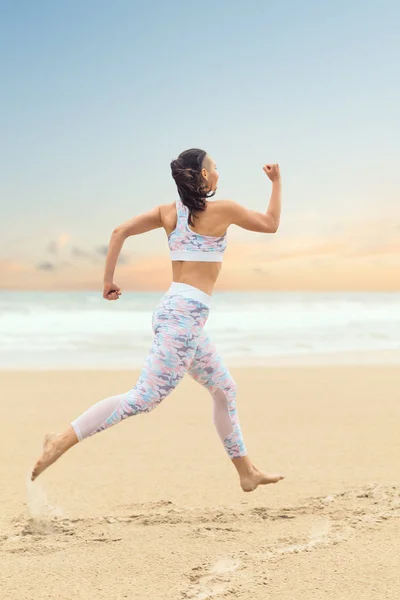 Jovem atleta mulher correndo na praia do mar — Fotografia de Stock