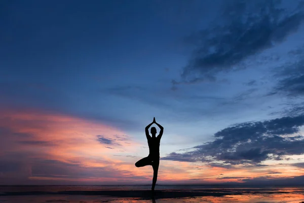 Silhueta foto de homem praticando ioga ao pôr do sol — Fotografia de Stock