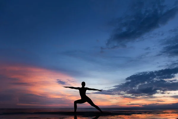 Silhueta foto de mulher praticando ioga ao pôr do sol — Fotografia de Stock