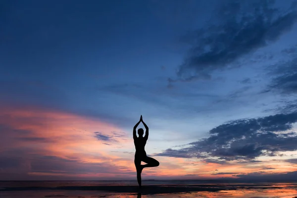 Silhueta foto de mulher praticando ioga ao pôr do sol — Fotografia de Stock