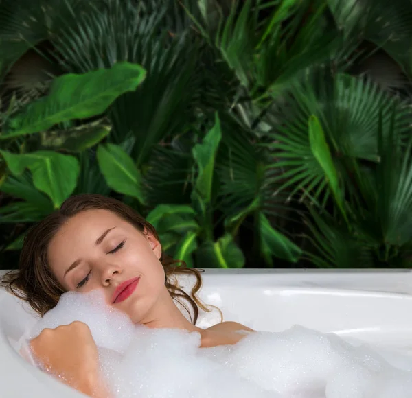 비누 거품이 있는 온수 욕조에서 휴식을 취하는 여성 — 스톡 사진