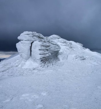 Taş dokulu ilginç ile dondurulmuş frost ve sanki masal dünyasında dev kar. Yüksek dağlar, sis ve kasvetli mistik gökyüzü güzel manzara. Yer yer Karpatlar.