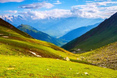 Çim kayalarda üzerinden en yüksek dağların muhteşem manzarası bulutlar doğal çayırlar ve güneş ışığı açın. 