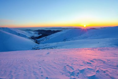 Üzerinde net bir kış günü, hangi kalın sis üzerinde çam ormanları ile kaplı dağ tepeleri rulo üzerinde görülen pitoresk kar kar ile toz kar Vadisi'nden olabilir. Güzel kış arka plan.