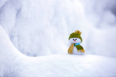 Yeşil şapkalı güzel rüya kardan adam tepeye yakın ilginç dokulu karda soğuk kış gününde duruyor.