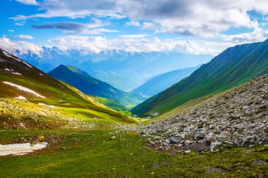Çim kayalarda en yüksek dağların muhteşem manzarası bulutlar doğal çayırlar ve güneş ışığı açın. Konuma yerleştirin Üst Svaneti, Georgia, Avrupa. 