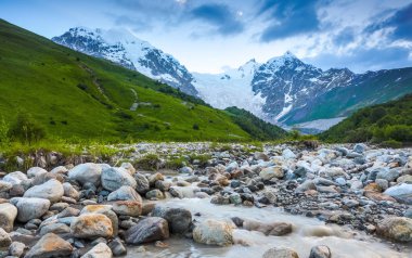Nehirden shore taşlar ile kaplı, fantastik buzul ve dik kayalık dağlar karla kaplı yeşil çayırlar açılır. Mutlu bir yaşam tarzı. Güzel evren.