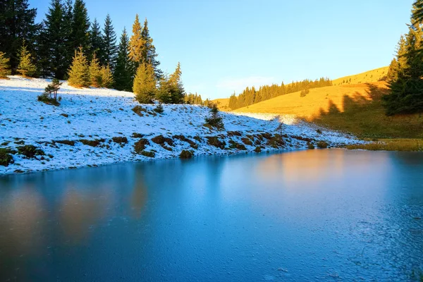 Dağlar ve karla kaplı çimenler fantastik görünümünü sahilden açılır. Göl donmuş su, ilginç frost ve doku ile.