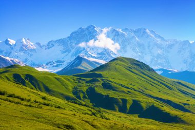 Güneşli gün yüksek dağlarda manzara güzel görünümüne çim kaplı Yeşil Vadi tarafından açılır. Üst Svaneti, Georgia, Avrupa. Mutlu bir yaşam tarzı. Güzel evren