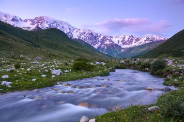 Nehirden shore taşlar ile kaplı, fantastik buzul ve dik kayalık dağlar karla kaplı yeşil çayırlar açılır. Mutlu bir yaşam tarzı. Güzel evren.