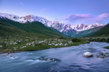 Nehirden shore taşlar ile kaplı, fantastik buzul ve dik kayalık dağlar karla kaplı yeşil çayırlar açılır. Mutlu bir yaşam tarzı. Güzel evren.