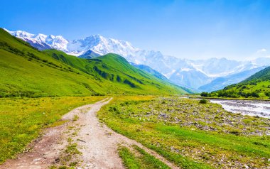 Geniş yoldan karla kaplı rocky Dağları, yeşil tepelerin ve çayırlar büyüleyici görünümünü açar. Üst Svaneti, Georgia, Europe.  