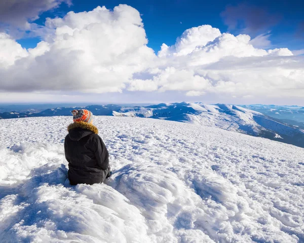 追梦女孩正坐在高山在寒冷冬日里看山风光和自然的多雪小山 — 图库照片