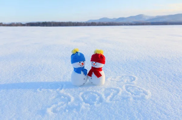 Happy couple of snowman in love standing on the snow. Writings 2020. Landscape with mountains in the cold winter day