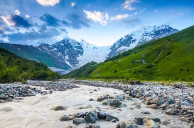 Nehirden shore taşlar ile kaplı, fantastik buzul ve dik kayalık dağlar karla kaplı yeşil çayırlar açılır. Mutlu bir yaşam tarzı. Güzel evren.