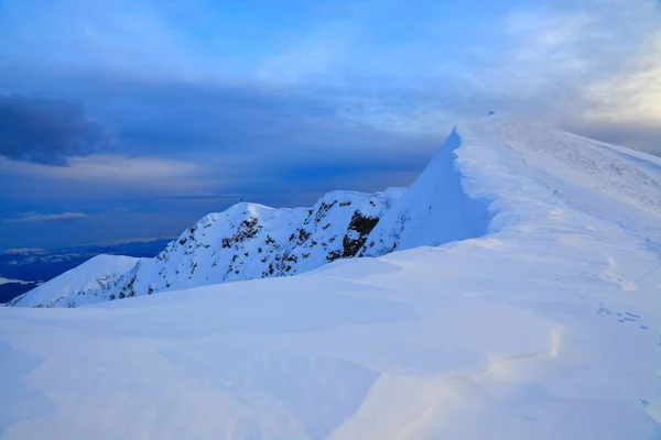 ふわふわの雲で覆われて 青空のブルー シャドウを落とす雪氷で覆われている山の頂上 — ストック写真