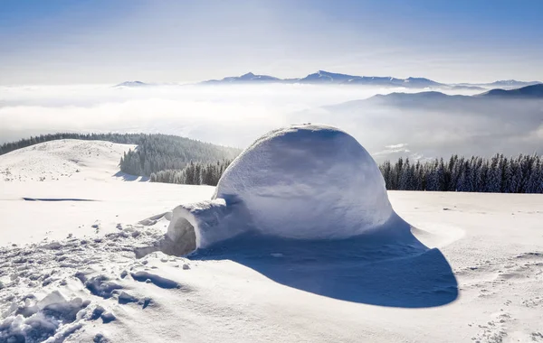 大圆的冰屋站在被雪覆盖的山上 吸引着游客的视线 神话般的冬季背景的传单 — 图库照片