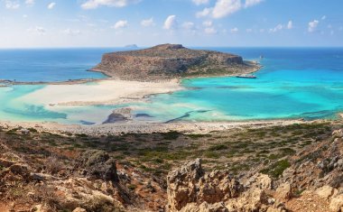 Popüler turistik tatil, sahil Adası Girit, Yunanistan. Bir kayalık tepe, Balos plaj harika beyaz kum, deniz ve dağ ile muhteşem manzara. Demirli bir gemi. Yaz güneşli bir günde manzara.