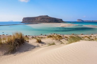 Beyaz insanlarla beach nerede alt-ebilmek var olmak seen, denizin dibinde kum. Güzel dağlar bir mavi ufuk üzerinde. İnanılmaz Balos. Güneşli bir yaz bir manzara. Girit Adası, Yunanistan.