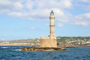 Deniz feneri. Antik mimari ile kayalık sahile güzel bir görünüm. Liman turistik kenti Chania, Creete adası, Yunanistan. Dalgalar la mavi deniz.