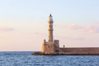 Deniz le çevrili güzel antik deniz feneri ile sahne. Pembe ışıkla gün batımı gökyüzü. Yüksek dağlar. Konumu liman Chania, Creete adası, Yunanistan.