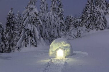 Gece kışı dağ manzaraları. Igloo karlı çimlerin üzerinde duruyor. Işıklı ev. Karpat Dağları, Ukrayna, Avrupa.