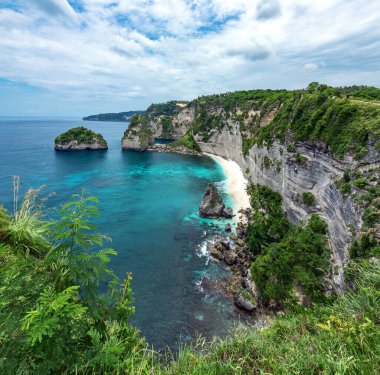 Landscape of sunny day with turquoise ocean, blue sky and mountains. View of Diamond beach, Nusa Penida, Bali island, Indonesia. Wallpaper background. Natural scenery. Romantic relax place.