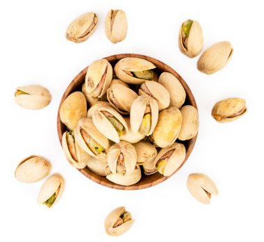 Fıstık bir ahşap plaka ve beyaz bir arka plan üzerinde dağınık. Üstten görünüm.