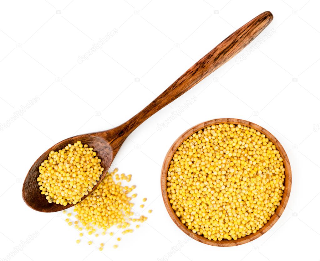 Millet in wooden spoon and plate on a white. The form of the top.