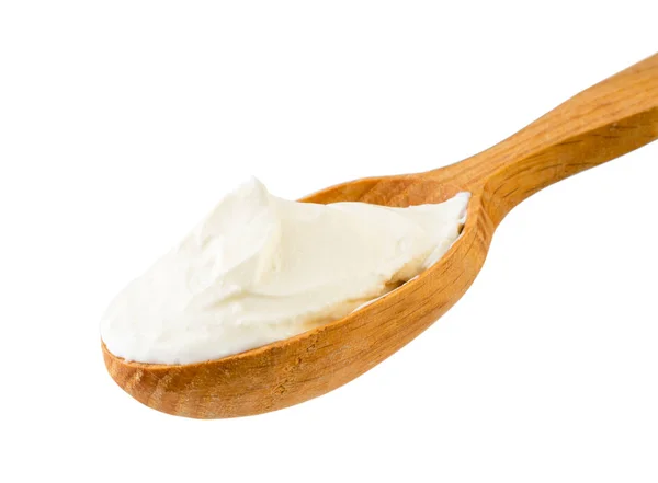 Sour cream in wooden spoon close - up on a white. Isolated. — Stock Photo, Image