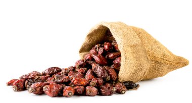 Beyaz bir arka planda, izole torbadan kurutulmuş kuşburnu döktüm.