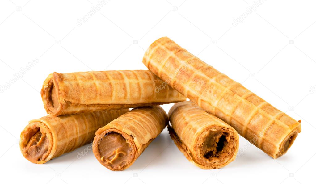 Heap of wafer tubes with condensed milk on a white, isolated.