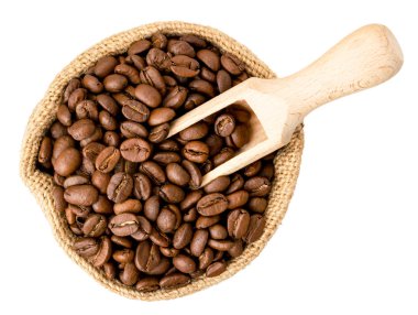 Kahve çekirdekleri bir çanta ve bir beyaz tahta kaşık. Üst formu.