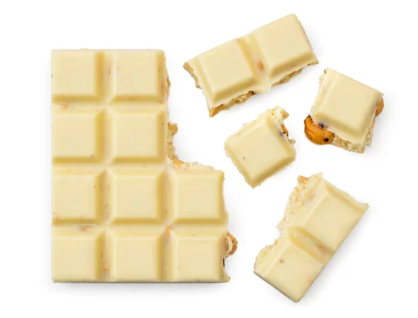 Broken white chocolate bar with nuts on a white. View top — Stock Photo, Image