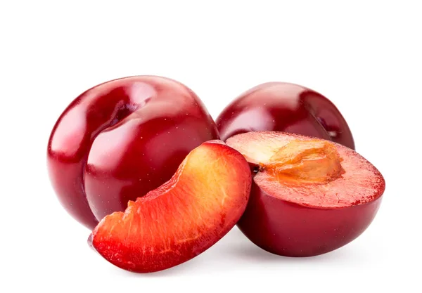 Ameixas vermelhas maduras, metade e parte em um branco, isolado . — Fotografia de Stock