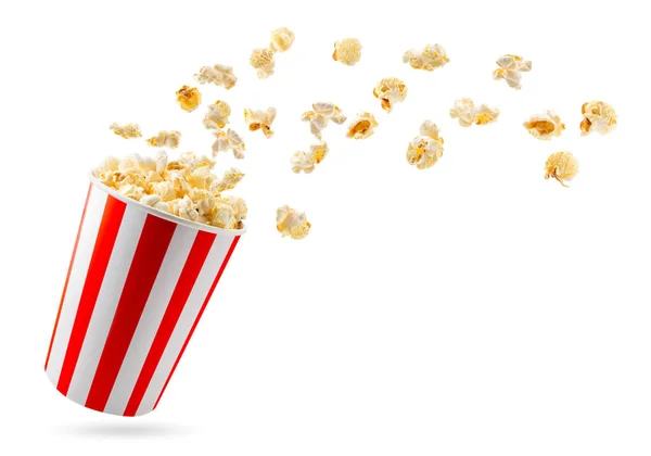 Popcorn fliegt aus einem vollen Eimer in Großaufnahme auf einem weißen. isoliert. — Stockfoto
