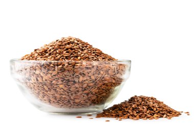 Cam bir tabakta keten tohumu ve beyaz arka planda dağınık bir yığın..