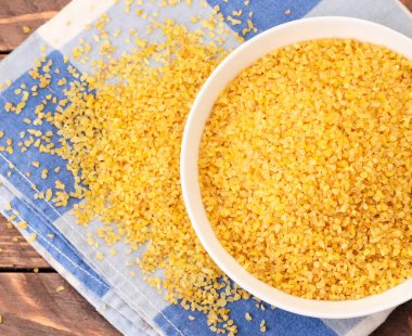 Beyaz arka planda, kapalı bir plakada kuru bulgur. Yukarıdan görünüm