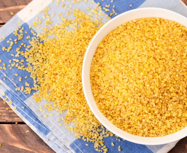 Beyaz arka planda, kapalı bir plakada kuru bulgur. Yukarıdan görünüm