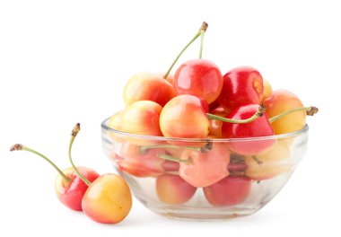 Kırmızı-sarı kiraz, beyaz arka planda yakın plan bir tabakta. İzole edilmiş