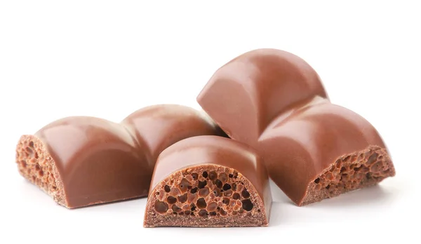 Leche trozos de chocolate poroso sobre un fondo blanco. Aislado — Foto de Stock