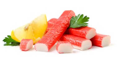 Beyaz arka planda yengeç çubukları, maydanoz ve limon dilimi. İzole edilmiş