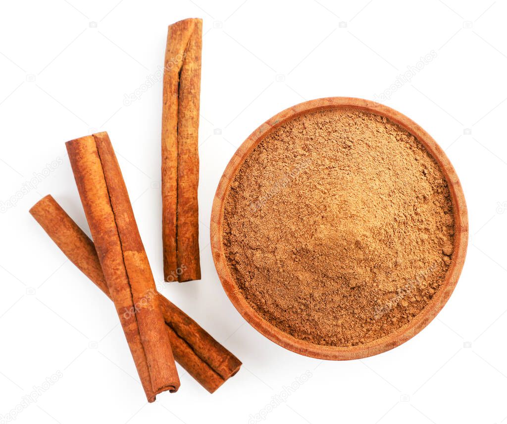 Cinnamon sticks and cinnamon powder in a plate close-up on a white background, isolated. The view from top