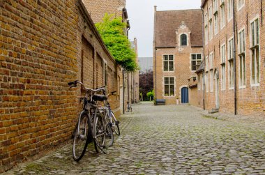Begijnhof Leuven, Belçika eski sokakta duvara yaslanmış bisiklet
